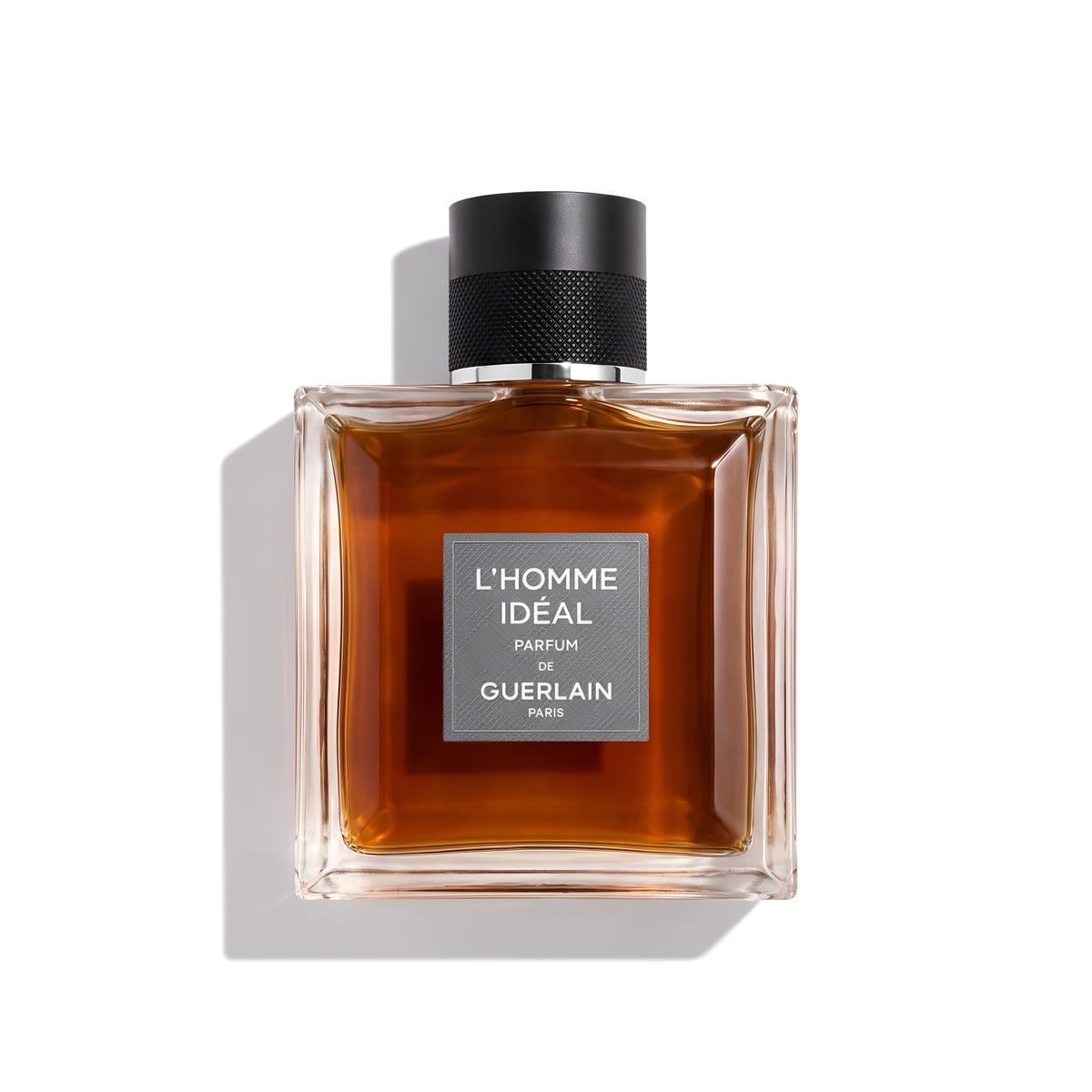 Bottle of Guerlain L'Homme Ideal Parfum fragrance on a white background with soft shadow