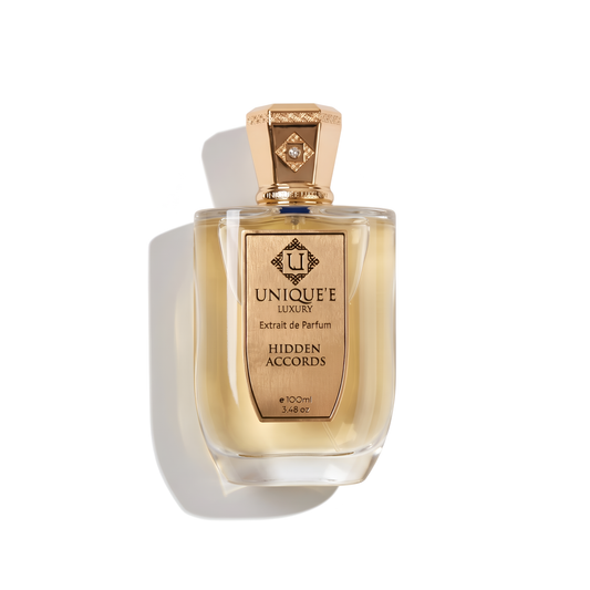 Bottle of Unique'E Luxury Hidden Accords Extrait fragrance on a white background with soft shadow
