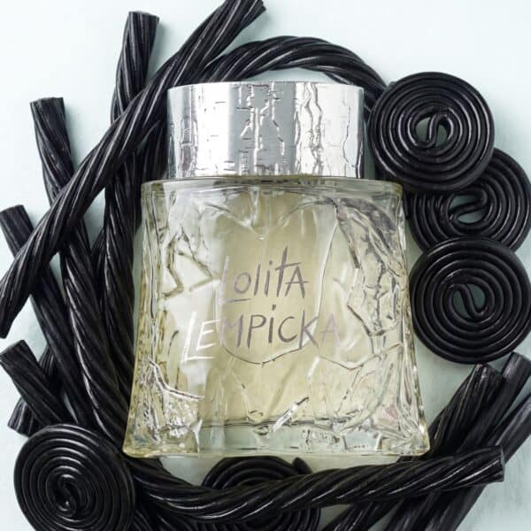 25 Luxurious perfume bottle surrounded by black candies, highlighting artisanal fragrance creation.