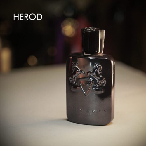 A 125ml bottle of Parfums de Marly Herod Eau de Parfum with a blackish design and an embossed logo, topped with a matching black cap, placed on a white table.