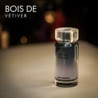 A 100ml bottle of Karl Lagerfeld Bois de Vetiver Eau de Toilette with a clear glass body, silver cap, and a cylindrical shape, set on a white table.