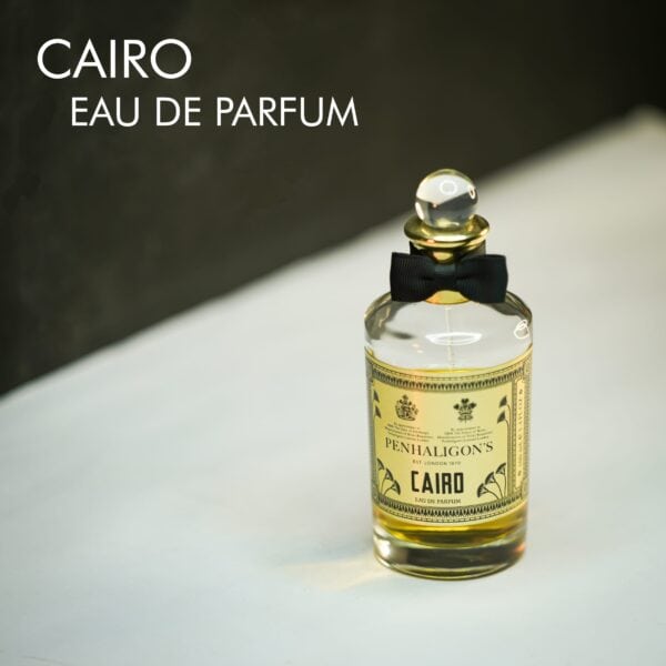 A clear bottle with a black bow tie of Penhaligon's Cairo Eau de Parfum with black font labels.