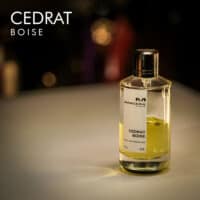 A 120ml bottle of Mancera Cedrat Boise Eau de Parfum with a clear glass design, green, yellow liquid, white label on a brown table.