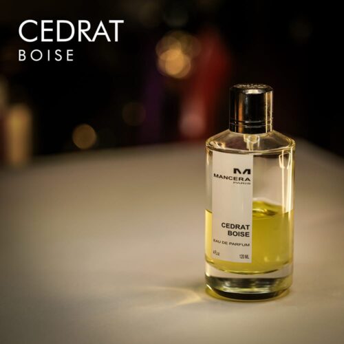 A 120ml bottle of Mancera Cedrat Boise Eau de Parfum with a clear glass design, green, yellow liquid, white label on a brown table.