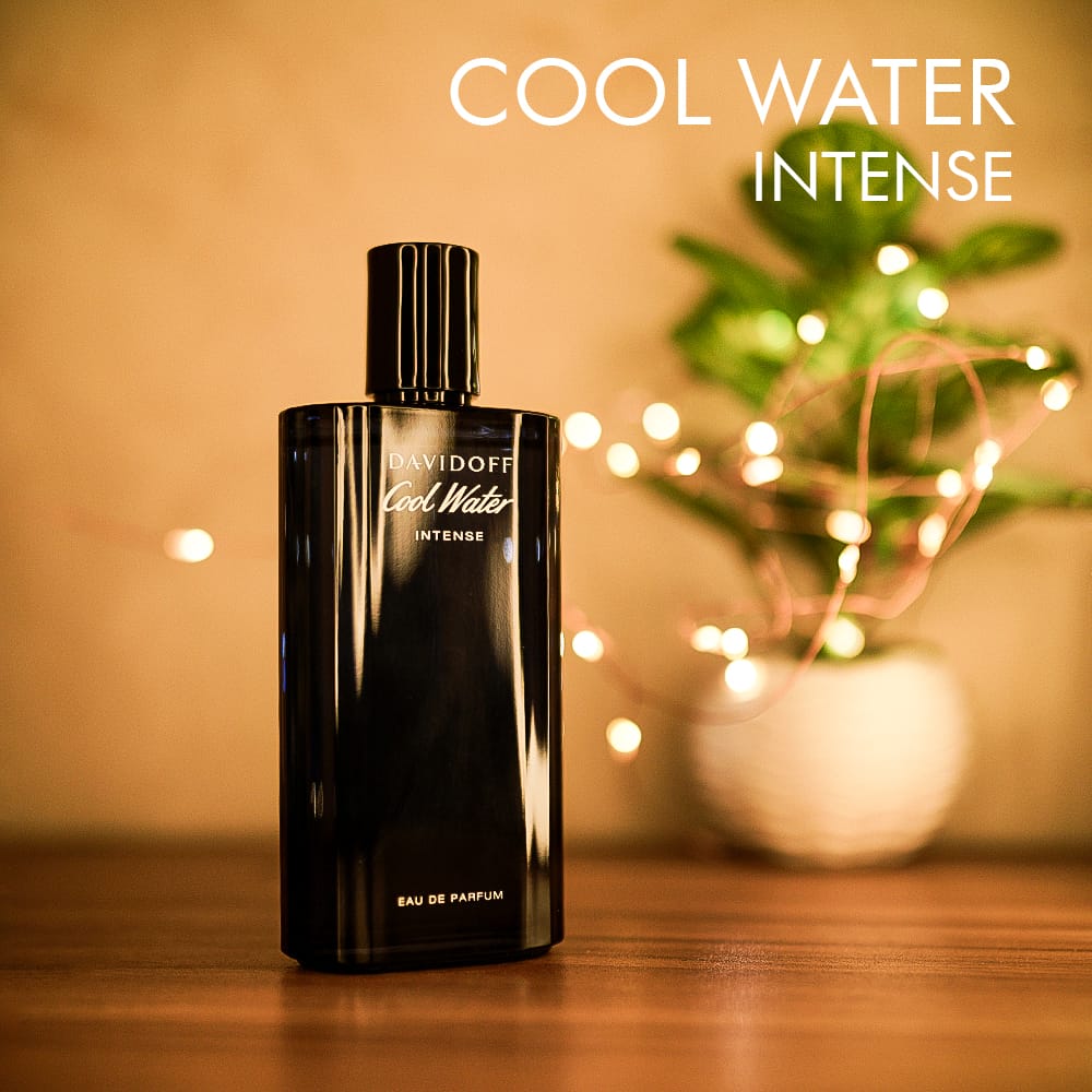 A 125ml bottle of Davidoff Cool Water Intense Eau de Parfum with a dark blue glass, and a deep blue cap, placed on a brown table.