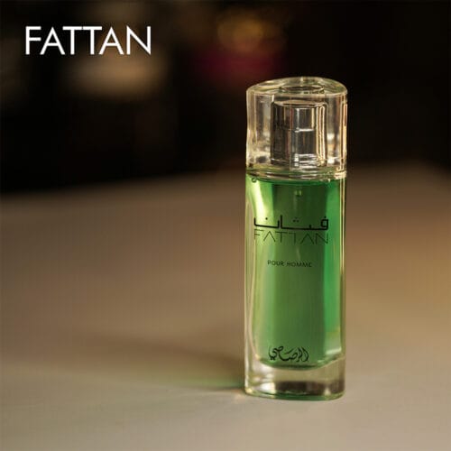 A 100ml bottle of Rasasi Fattan Eau de Parfum with a sleek rectangular clear glass design, green liquid, and a metallic silver cap, placed on a white table.