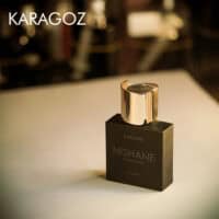 A 50ml bottle of Nishane Karagoz (Batch 2018) Extrait de Parfum with a sleek, dark bottle featuring gold cap, gold detailing, placed on a white table.