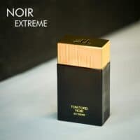 A dark tinted bottle with a golden cap of Tom Ford Noir Extreme Eau De Parfum with gold font labels.