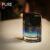 A 100ml bottle of Paco Rabanne Pure XS Eau de Toilette with a blue and black and clear glass design on a brown table.