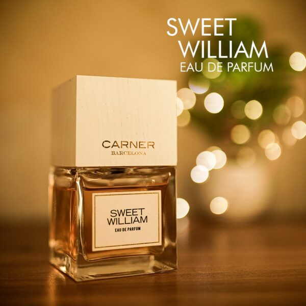 A 100ml bottle of Carnar Barcelona Sweet William Eau de Parfum with a square glass design and white cap on a brown table.