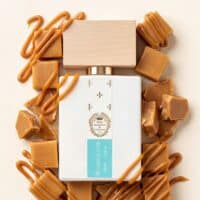 18 Luxurious caramel perfume bottle surrounded by caramel candies and drizzled caramel sauce, emphasizing sweet scent and indulgence.