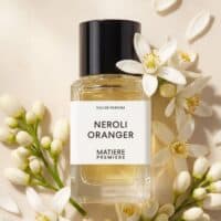 Elegant Neroli Oranger perfume bottle surrounded by white floral accents, capturing fresh citrus and floral aroma.