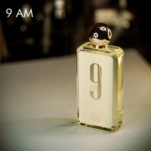 a 100ml bottle of Afnan 9AM Eau de Parfum with a sleek rectangular glass design, white label, and a chrome cap on a brown table.