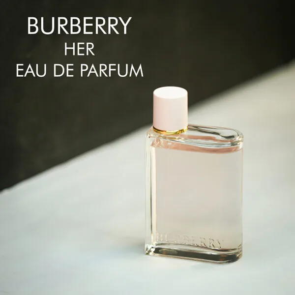 A clear bottle with light pink liquid of Burberry Her Eau De Parfum with engraved labels.
