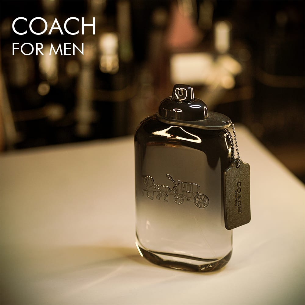 a 100ml bottle of Coach for Men Eau de Toilette with a transparent glass design, a black gradient base, and a black cap on a white table