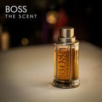a 100ml bottle of Hugo Boss Boss The Scent Eau de Toilette with an amber-tinted glass design and silver cap on a white table
