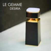 A black bottle with gold and lavender accents of Bvlgari Le Gemme Desiria Eau De Parfum with engraved labels.