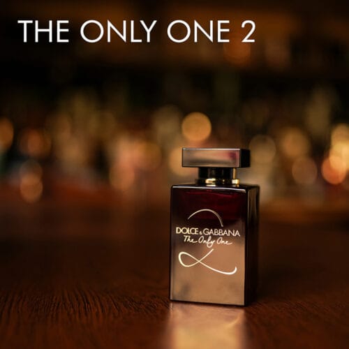 a 100ml bottle of Dolce & Gabbana The Only One 2 Eau de Parfum with a burgundy glass design and red cap on a brown table