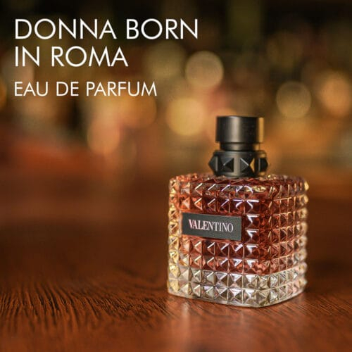 A 100ml bottle of Valentino Donna Born in Roma Eau de Parfum with a pink design and black cap on a marble table