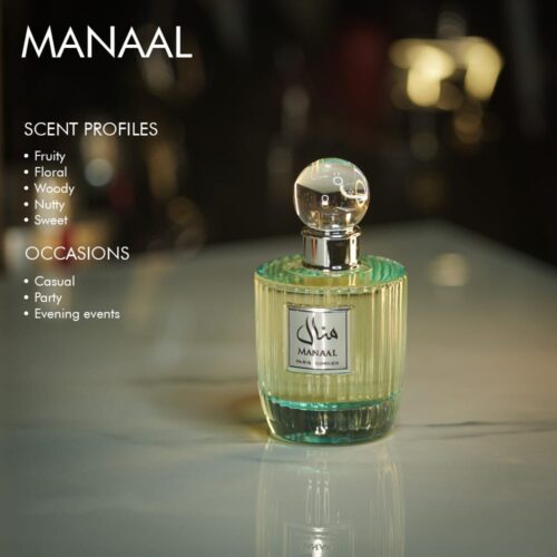 A 100ml bottle of Paris Corner Manaal Eau de Parfum with a clear cap and green design on a marble table