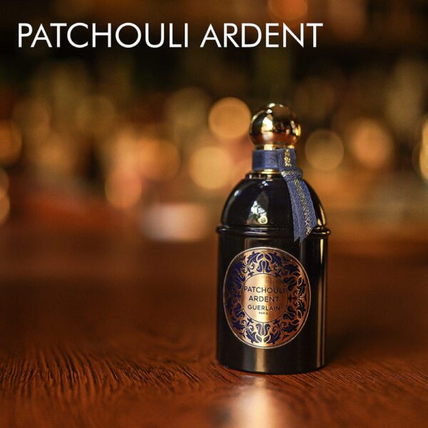 A 100ml bottle of Guerlain Patchouli Ardent Les Absolus d’Orient Eau de Parfum with a dark blue and gold design on a brown table