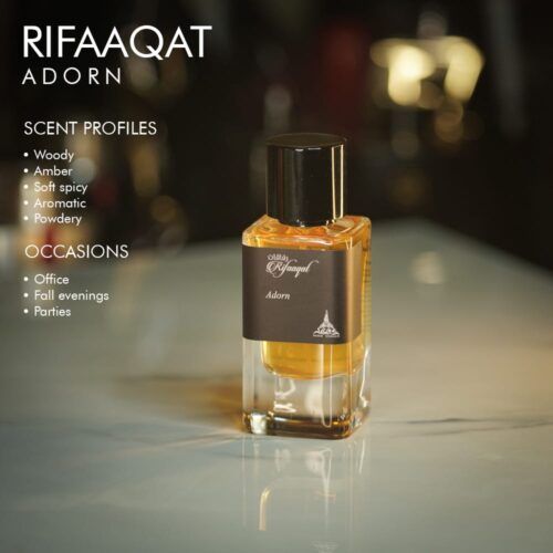 A 100ml bottle of Paris Corner Rifaaqat Adorn Eau de Parfum with a golden liquid and coffee label on a white table