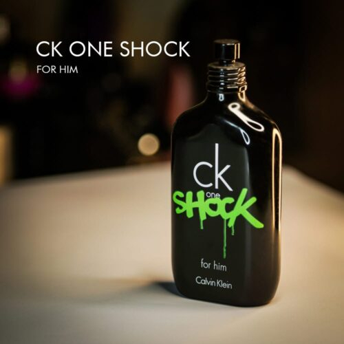 A 100ml bottle of Calvin Klein CK One Shock For Him Eau de Toilette with a black and green design on a white table