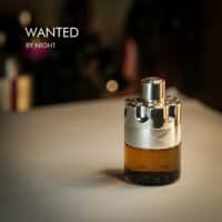 A 100ml bottle of Azzaro Wanted by Night Eau de Parfum with a silver and gold design on a white table