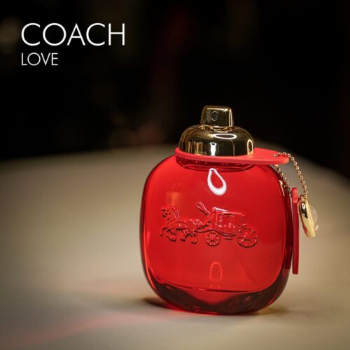 A 100ml bottle of Coach Love Eau de Parfum with a pink design and a gold cap on a white table