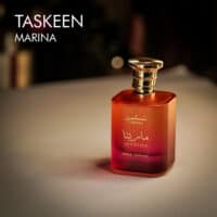 A 100ml bottle of Paris Corner Taskeen Marina Eau de Parfum with a red design on a white table