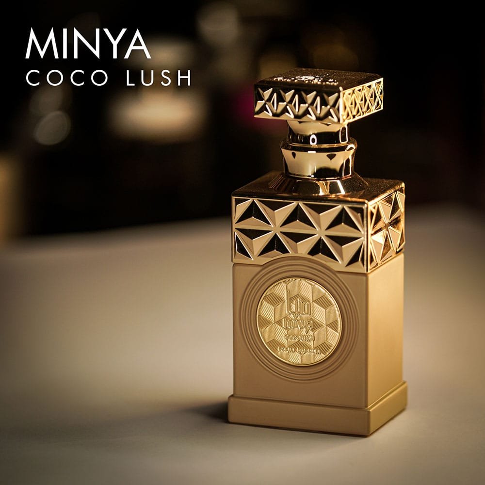 A 100ml bottle of Paris Corner Minya Coco Lush Eau de Parfum with a gold design on a brown table