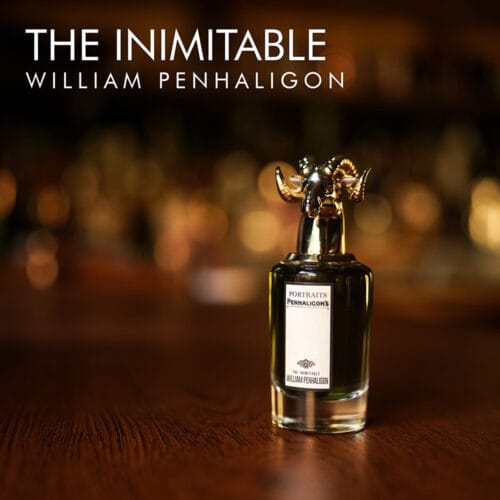 A 100ml bottle of Penhaligon's The Inimitable William Penhaligon Eau de Parfum with a clear cap and murky liquid with a white label on a brown table