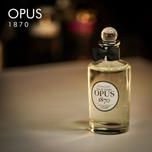 A 100ml bottle of Penhaligon's Opus 1870 Eau de Parfum with a clear cap and clear liquid with a white label on a brown table