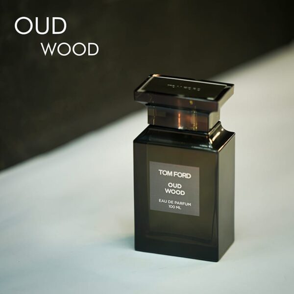 A dark tinted bottle of Tom Ford Oud Wood Eau De Parfum with white font labels.