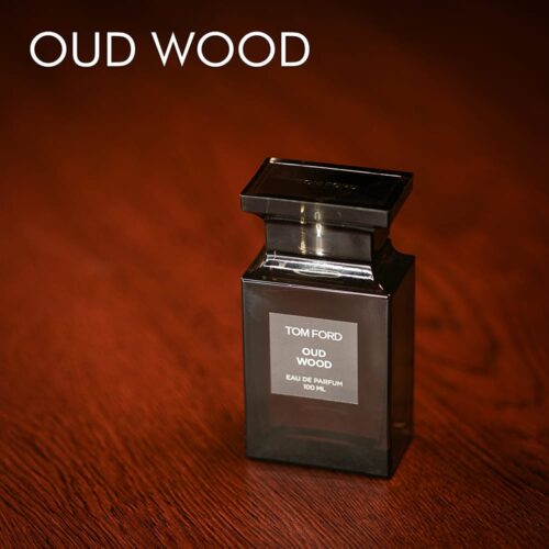 A 100ml bottle of Tom Ford Oud Wood Eau de Parfum with a brown colour and ash label on a brown table
