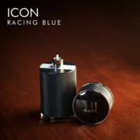 A 100ml bottle of Dunhill Icon Racing Blue Eau de Parfum with a blue and silver design on a brown table