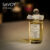 A 100ml bottle of Penhaligon's Savoy Steam Eau de Parfum with a clear cap and gold liquid with a white label on a brown table