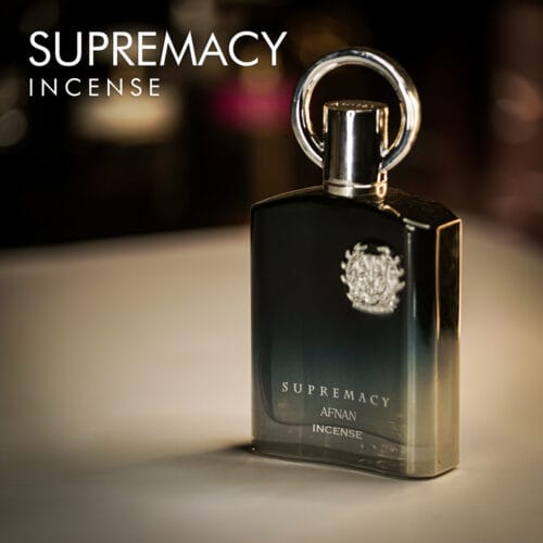 A 100ml bottle of Afnan Supremacy Incense Eau de Parfum with a black and silver design on a brown table