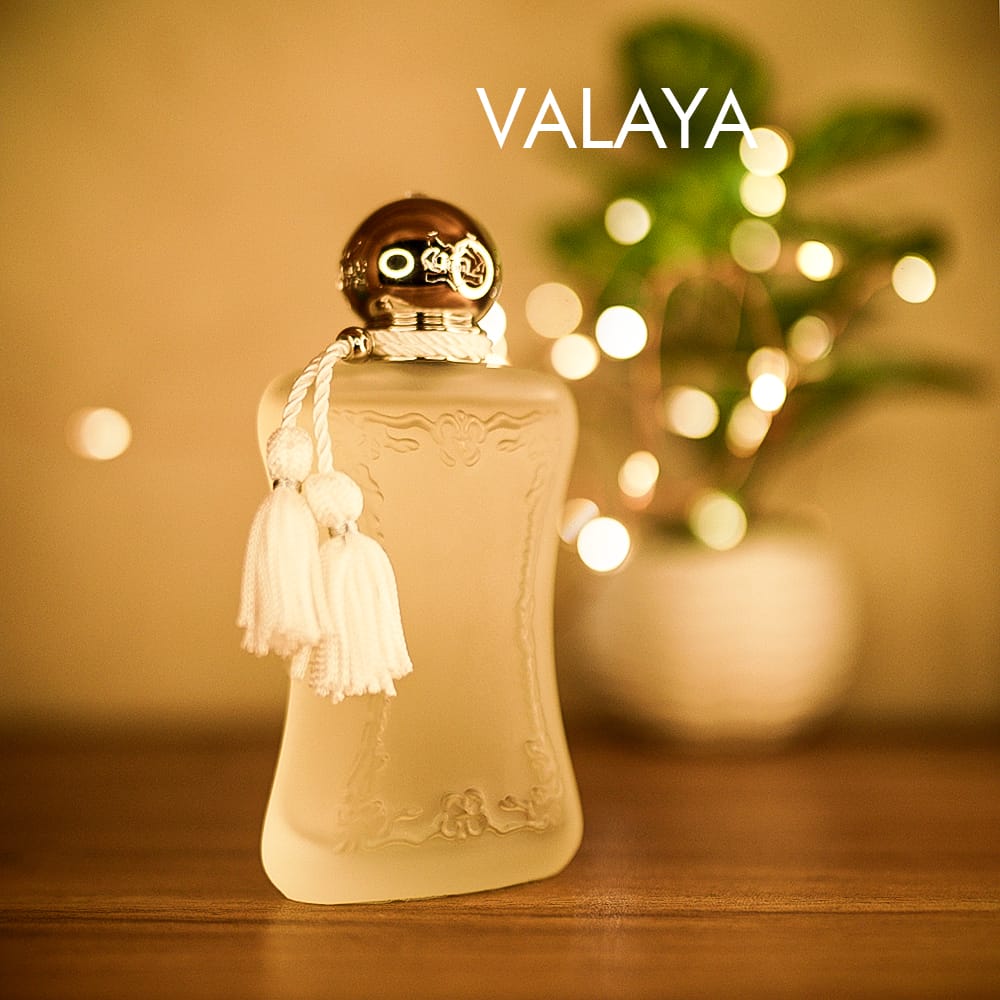 A 75ml bottle of Parfums de Marly Valaya Eau de Parfum with a frosted semi transparent glass body, a chrome cap, a brown table.