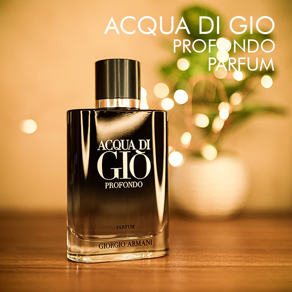 A 100ml bottle of Giorgio Armani Acqua Di Gio Profondo Parfum with a dark gradient glass body, a dark cap, and a silver logo on a brown table.