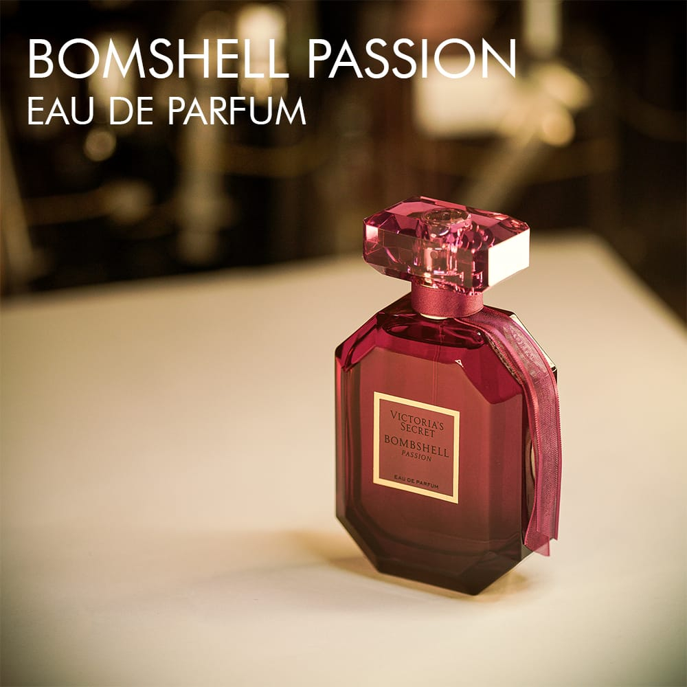 A 100ml bottle of Victoria’s Secret Bombshell Passion Eau de Parfum with a vibrant deep red design with golden label on a white table