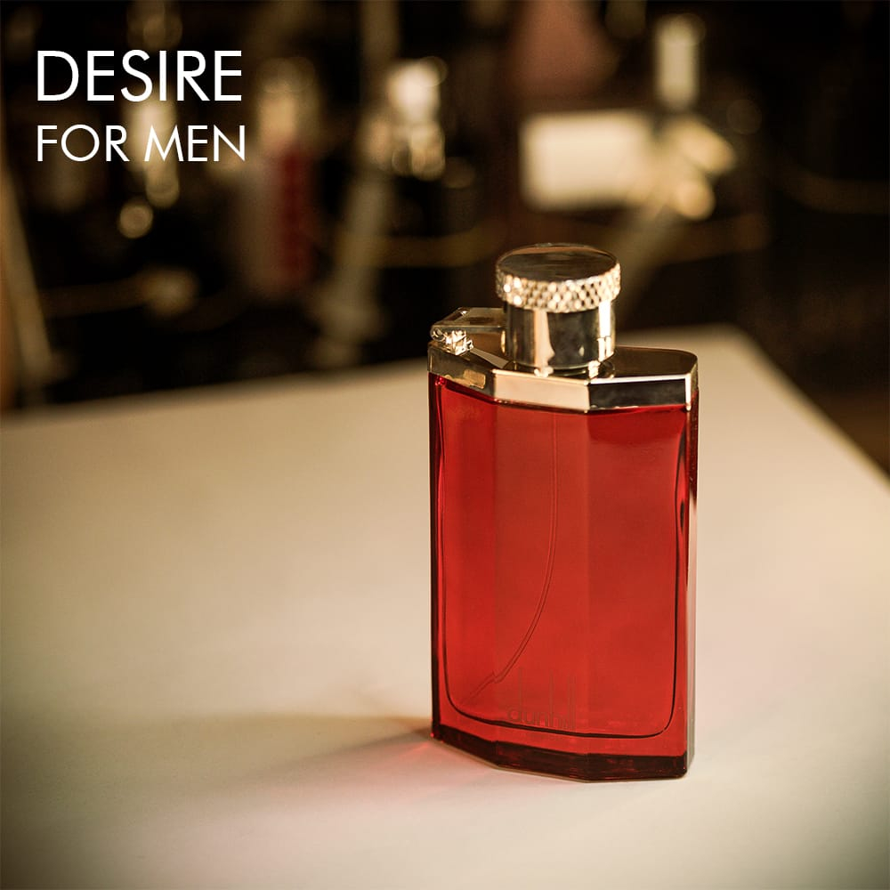 A 100ml bottle of Dunhill Desire Red Eau de Toilette with a striking red design on a white table