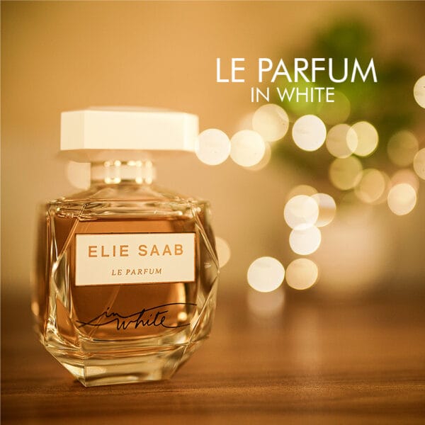 A 100ml bottle of Elie Saab Le Parfum in White with a transparent glass design and a white cap, white label on a brown table.