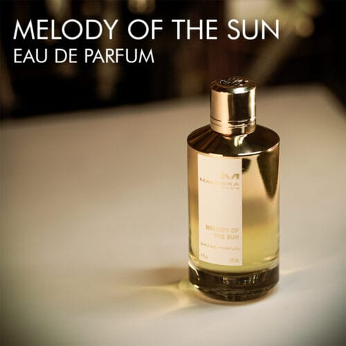 A 120ml bottle of Mancera Melody of the Sun Eau de Parfum with a sleek gold and white label design on a white table