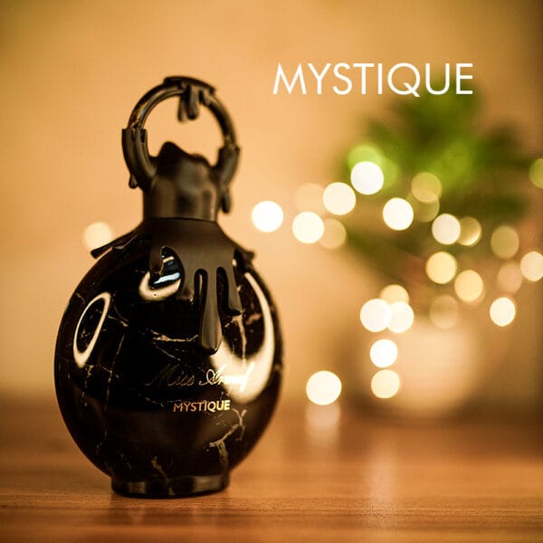 A 100ml bottle of Miss Armaf Mystique Eau De Parfum with a black bottle and ornate cap design on a brown table.