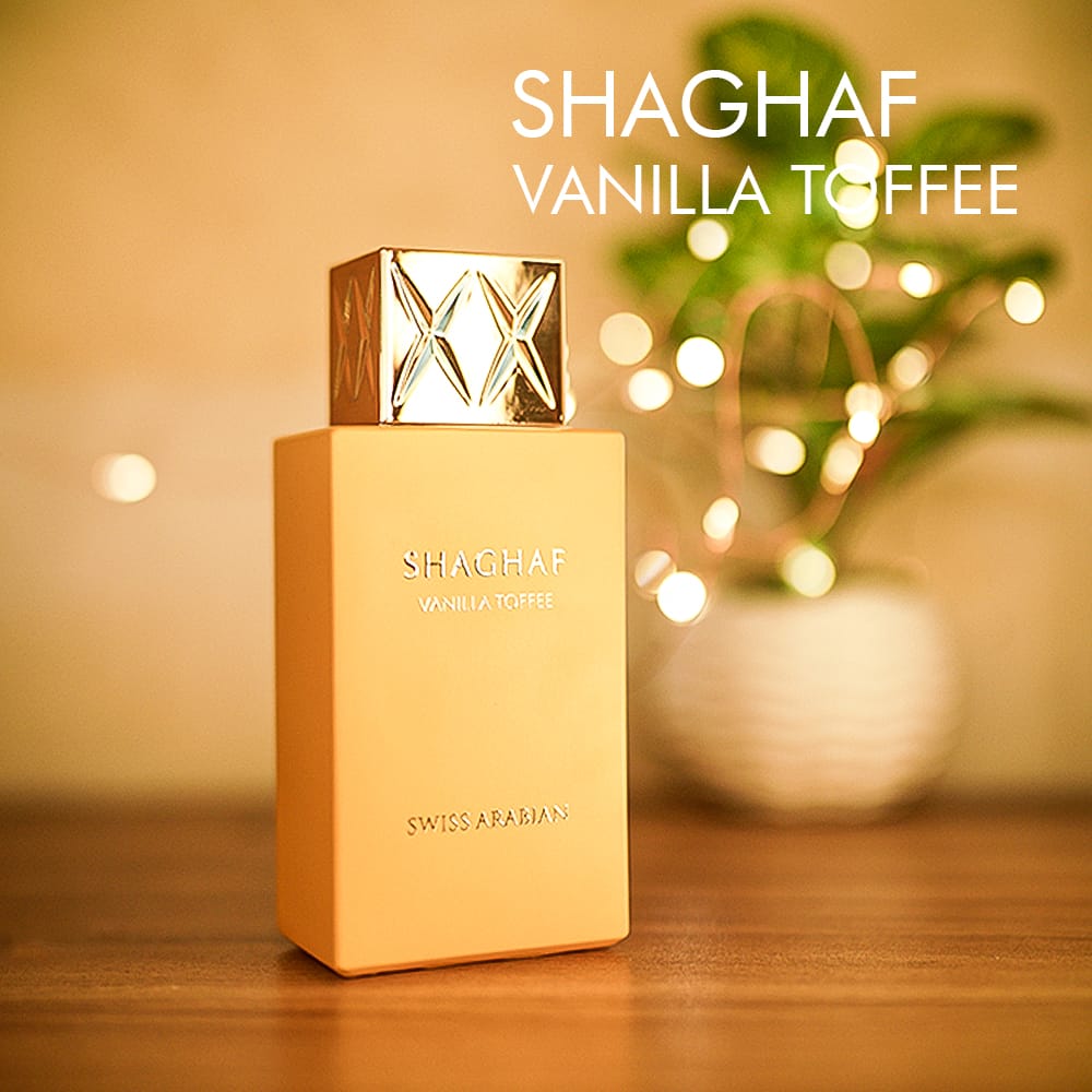 A 100ml bottle of Swiss Arabian Shaghaf Vanilla Toffee Eau de Parfum with a gold cap, orange bottle on a brown table.