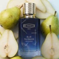 Fresh green pears surrounding a luxurious blue perfume bottle of Ex Nihilo Blue Talisman.