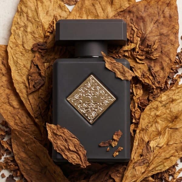 14 Luxury black perfume bottle with ornate gold design on dry autumn leaves.