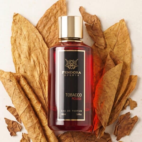 36 Bold red perfume bottle surrounded by dried autumn leaves, capturing luxurious scent of tobacco rouge.