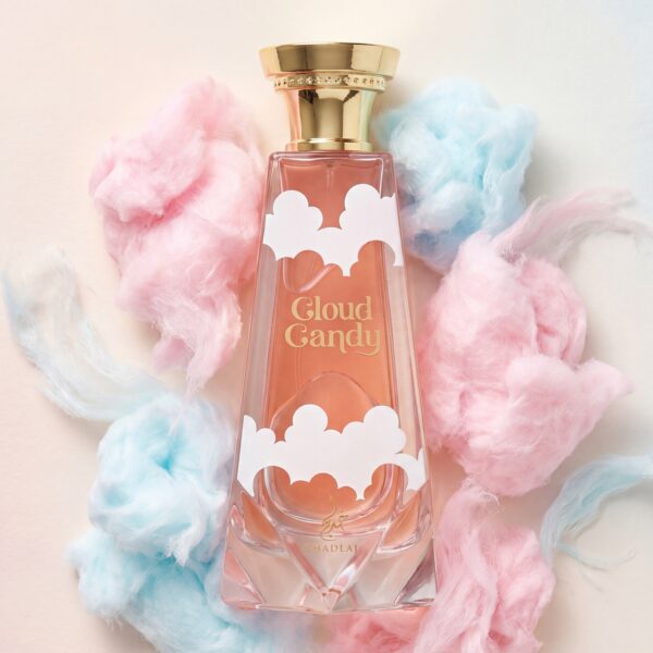 9 Soft pink and blue cotton candy around a "Cloud Candy" perfume bottle with gold accents, showcasing sweet, dreamy fragrances.